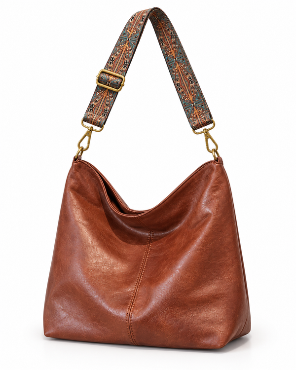 Bolso saco Pisa marrón con correa ancha estampada, sobre fondo blanco