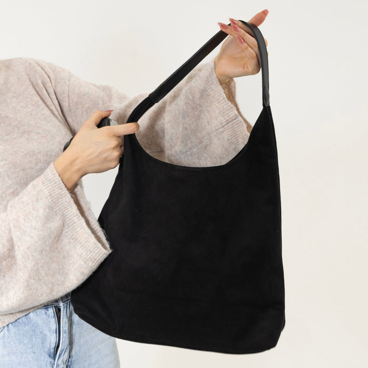 Bolso Siena en Negro sujeto por el asa, se aprecia el tamaño