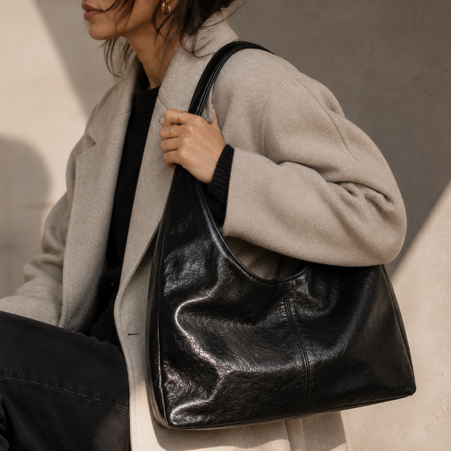 Bolso Firenze negro llevado al hombro con abrigo crema