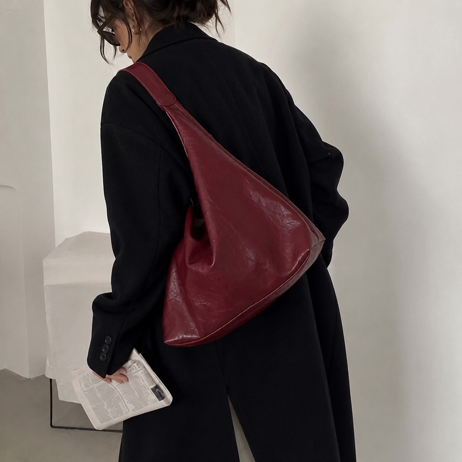 Bolso Firenze rojo burdeos llevado al hombro con jersey negro