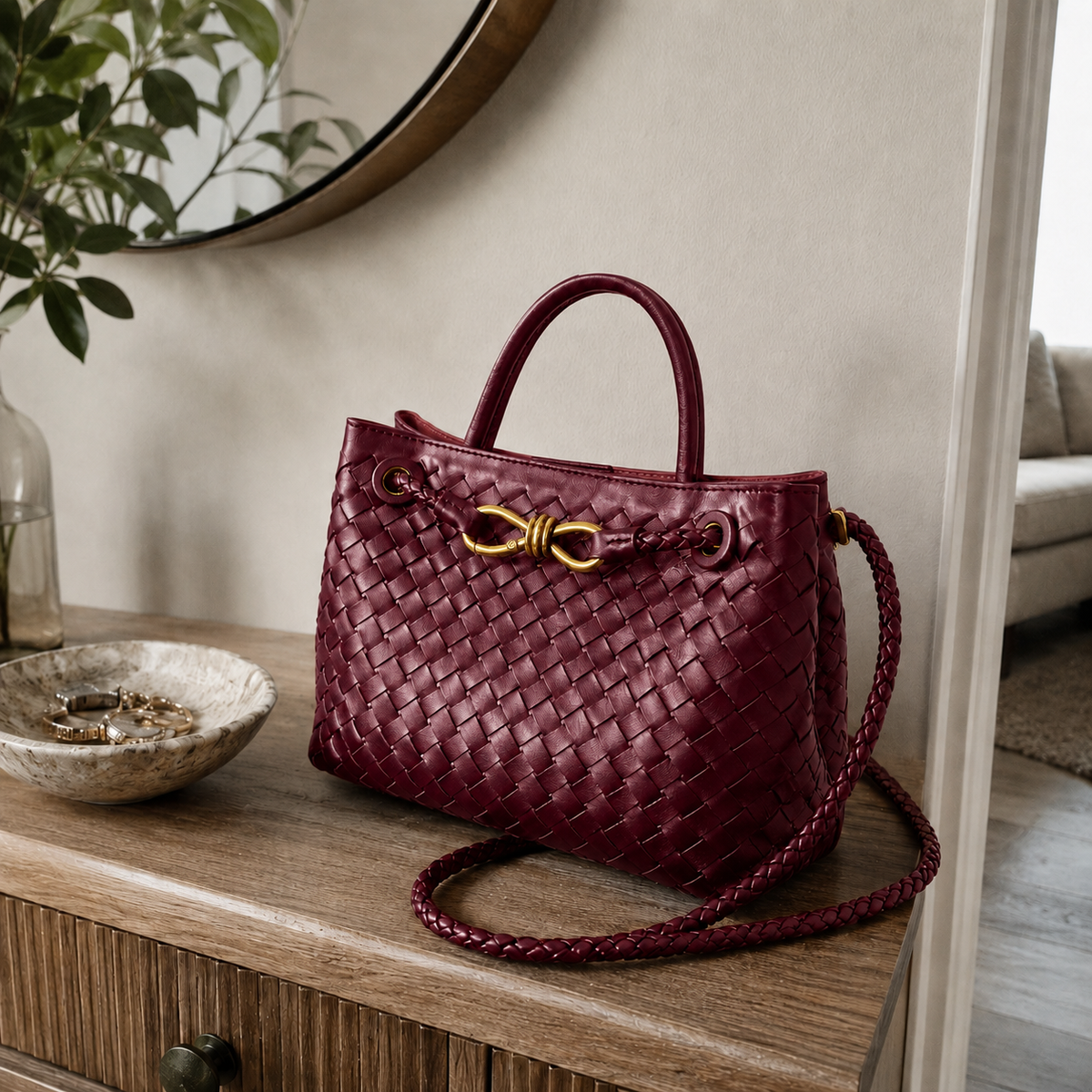 Bolso Positano en Burdeos sobre una consola de madera