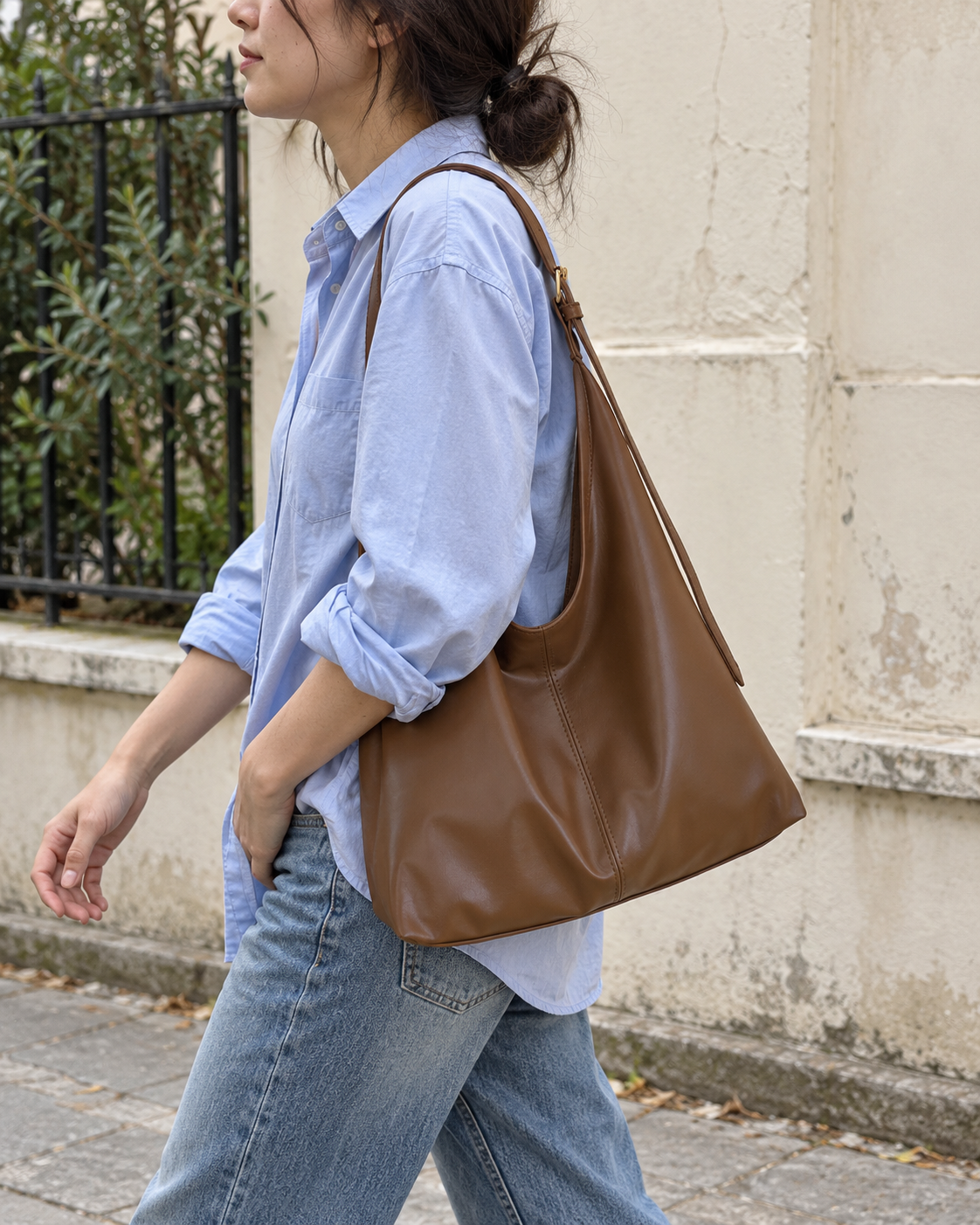 Bolso Lucca marrón llevado al hombro por la calle