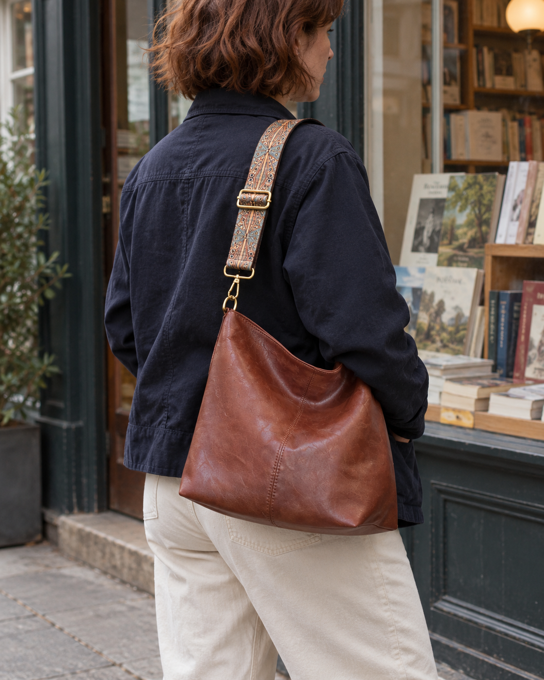 Bolso Pisa marrón llevado al hombro frente a una librería